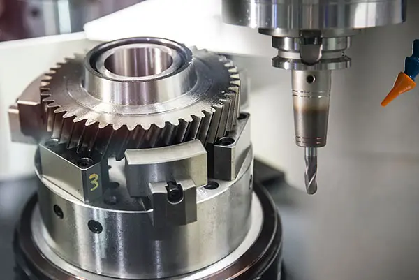 The CNC milling machine cutting the sample gear part. The mechanical part manufacturing process by CNC milling