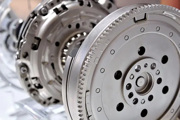 Car flywheel with a clutch in background, with selective focus.