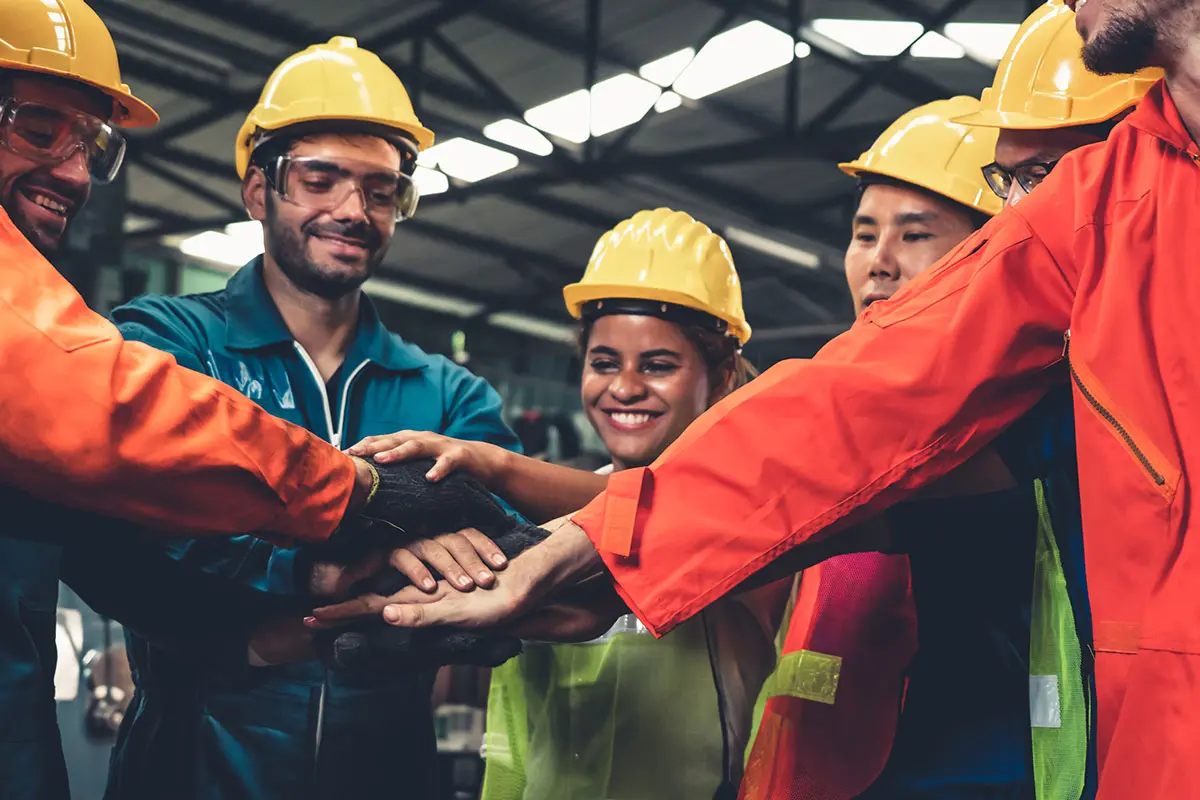 Skillful worker stand together showing teamwork in the factory. Industrial people and manufacturing labor concept.